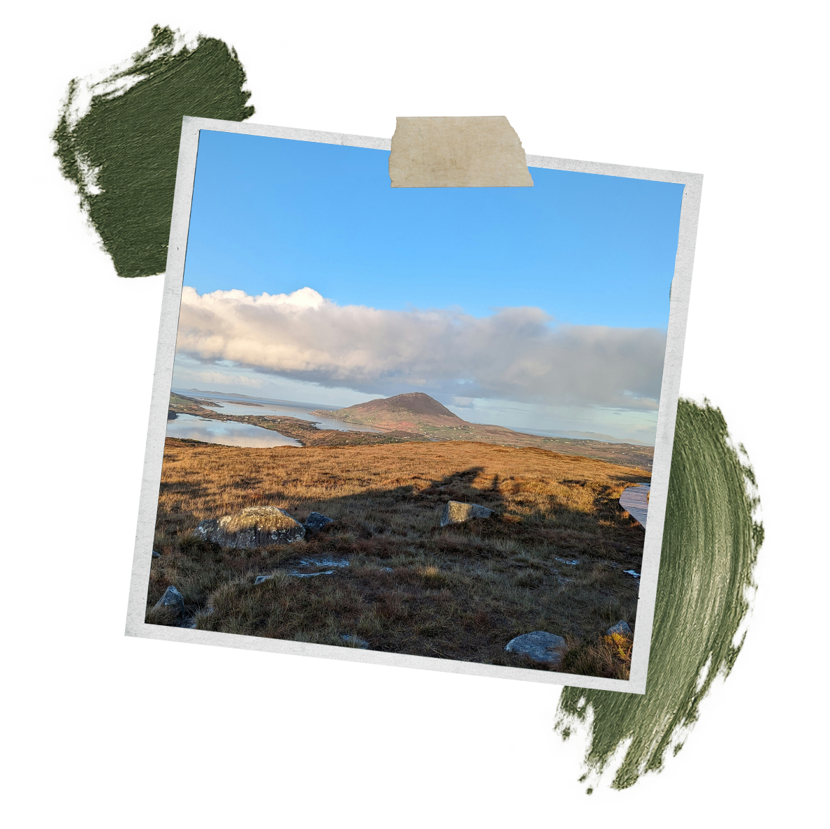 Tilted taped landscape photo showing a grassy moor, rocky hill, coastal inlets, clouds, and green terrain cutouts.